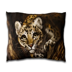 May include: A close-up of a leopard cub peeking out from behind a tree trunk. The cub has brown and black spots and is looking directly at the viewer with large, curious eyes.