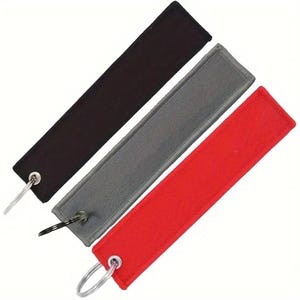K&ouml;nnte beinhalten: Drei Schl&uuml;sselanh&auml;nger mit Metallringen. Die Schl&uuml;sselanh&auml;nger sind aus Stoff und sind schwarz, grau und rot.