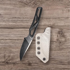 Op de afbeelding: Een zwart mes met een zwarte handgreep en een witte schede. Het mes heeft een zwart lemmet met een gekartelde rand. De schede heeft een wit carbonfiber patroon.