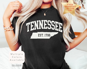 Könnte beinhalten: Schwarzes T-Shirt mit weißem Text "Tennessee Est. 1796" und einer weißen Umrandung des Bundesstaates Tennessee.