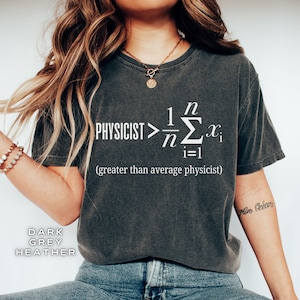 May include: A dark heather grey t-shirt with a white graphic of a math equation and the text "PHYSICIST > 1/n Σn=1 x_i (greater than average physicist)"