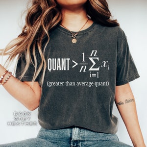 Può includere: Una t-shirt grigio melange scuro con una grafica bianca di un'equazione matematica e il testo "QUANT > 1/n Σ xi (greater than average quant)".