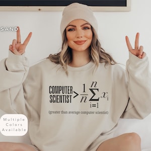 Puede incluir: Una sudadera beige con el texto "COMPUTER SCIENTIST > 1/n Σ(i=1 to n) x_i (greater than average computer scientist)" impreso en la parte delantera.