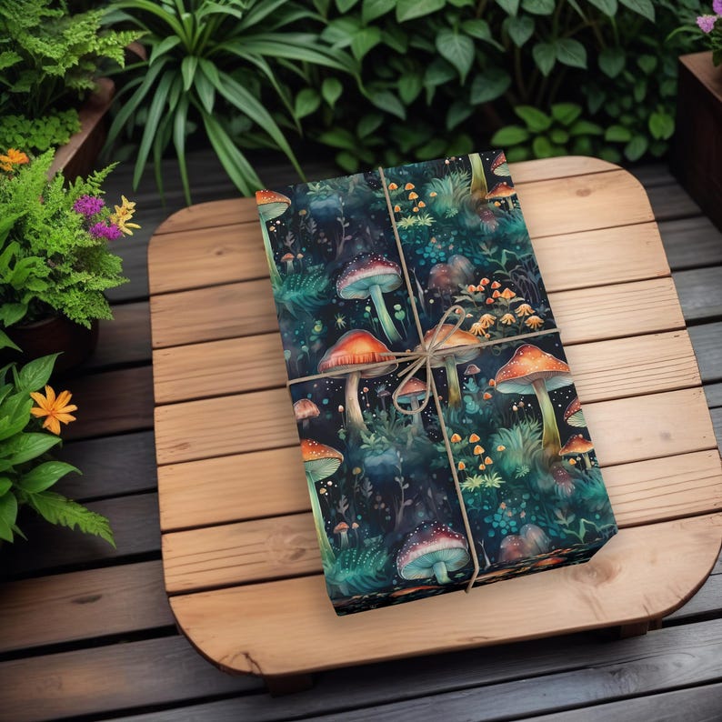 Pu&ograve; includere: Un regalo avvolto in carta da regalo blu scuro con un motivo a fungo. La carta &egrave; legata con spago e presenta una variet&agrave; di funghi in tonalit&agrave; di arancione, rosso e giallo.