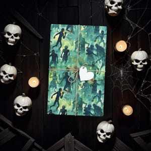 May include: A green and blue wrapping paper with a pattern of zombies. The paper is tied with twine and a white heart-shaped tag.