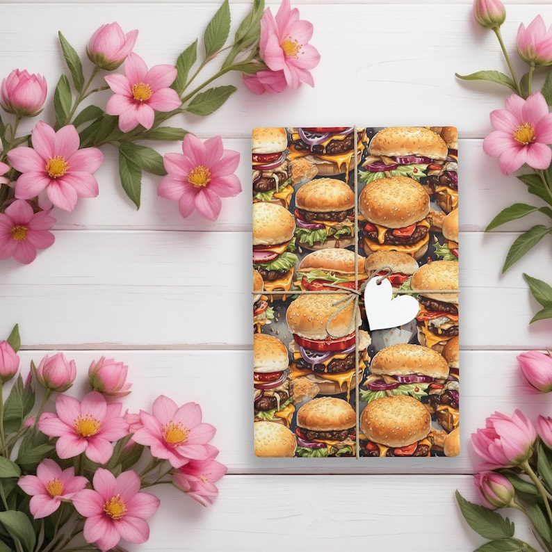 K&ouml;nnte beinhalten: Geschenkpapier mit einem Muster aus bunten, realistisch aussehenden Hamburgern. Das Geschenkpapier ist braun und hat einen wei&szlig;en herzf&ouml;rmigen Anh&auml;nger.