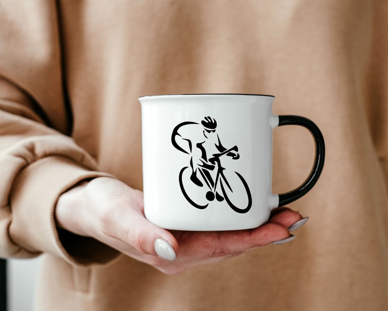 Puede incluir: Taza de cer&aacute;mica blanca con un contorno negro y una silueta negra de un ciclista montando una bicicleta.