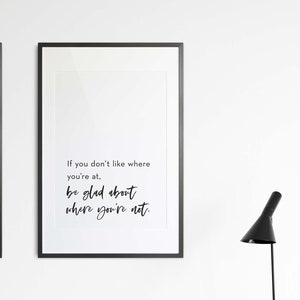 Pode incluir: Duas impressões emolduradas pretas com texto branco sobre um fundo branco. A impressão à esquerda tem o texto "the 12 steps" e lista os 12 passos. A impressão à direita tem o texto "If you don't like where you're at. be glad about where you're not."