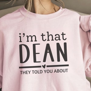 May include: A pink sweatshirt with the text "i'm that DEAN they told you about" in black lettering.