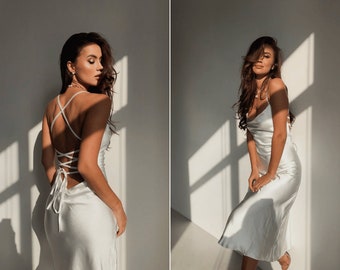 White backless silk slip dress for occasion. A-line satin dress cowl neck with lace-up open back. Strappy silk dress in milky colour.