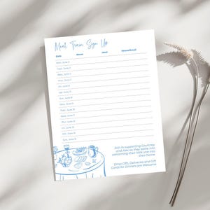 May include: A white paper with blue text and a blue illustration of a table with food. The text reads "Meal Train Sign Up" with fields for date, name, meal, and phone/email. Additional text invites support for Courtney and Alex.