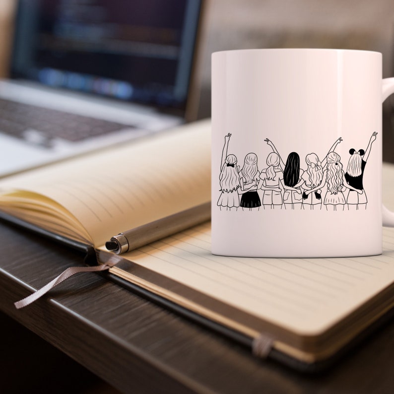 May include: White ceramic mug with a black line drawing of seven women standing back to back with their arms around each other. The women are wearing skirts and have their hair pulled back.