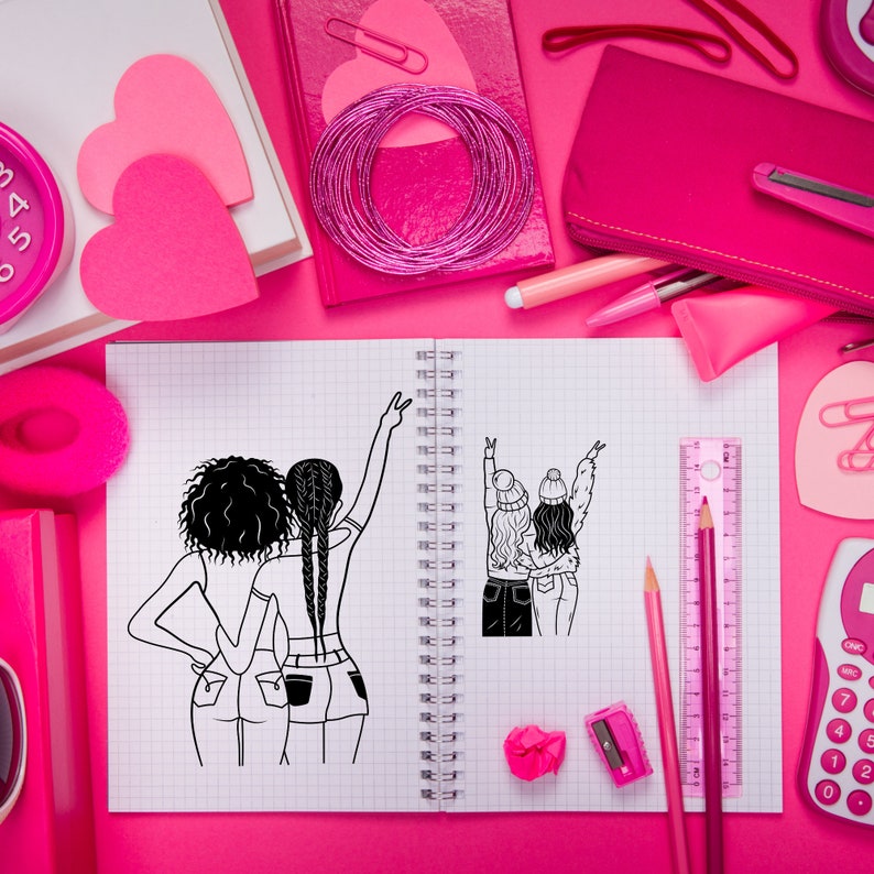 May include: A notebook with a black and white illustration of two people with their arms raised in the air. The notebook is open and has a spiral binding. There are various pink school supplies on a pink surface around the notebook.