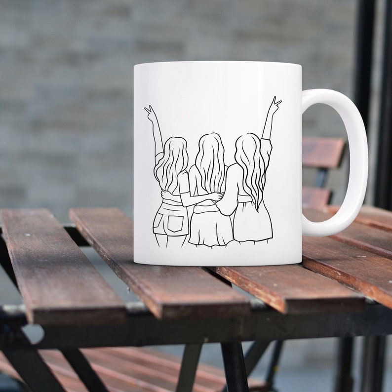 May include: White ceramic mug with a black line drawing of three women standing back to back with their arms around each other. The women are wearing casual clothing and have their hair down.