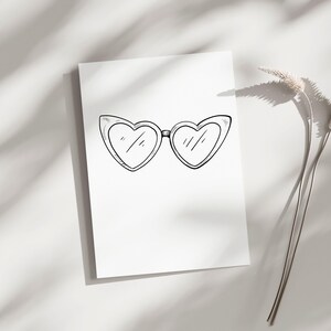 May include: A black and white illustration of heart-shaped sunglasses on a white background. The sunglasses are the focal point, with a simple, sketched design. The image is clean and minimalist, with soft shadows.