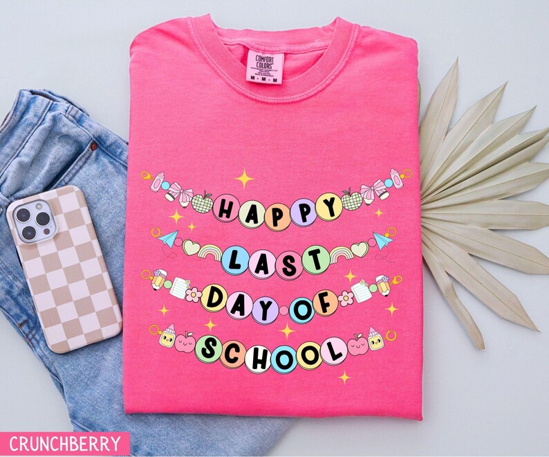 May include: Pink t-shirt with a colorful banner that reads "Happy Last Day of School".