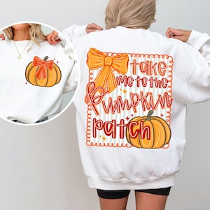 May include: White sweatshirt featuring a pumpkin graphic with an orange bow on the front and back. The back design includes the text "take me to the pumpkin patch" in orange and red, with a pumpkin illustration.