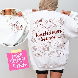 May include: White sweatshirt with brown text and graphics. The front features the words "touch down" with a bow graphic. The back displays football-themed illustrations and the words "Touchdown Season".
