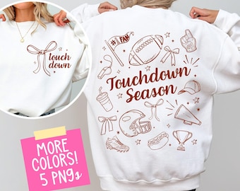 May include: White sweatshirt with brown text and graphics. The front features the words "touch down" with a bow graphic. The back displays football-themed illustrations and the words "Touchdown Season".
