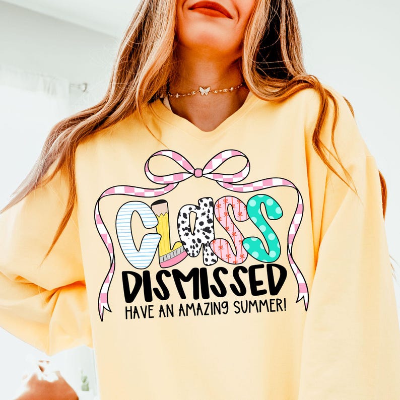 May include: Yellow sweatshirt with a pink and white checkered ribbon bow and the text "Class Dismissed Have an Amazing Summer!" in colorful letters.