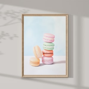 Puede incluir: Una pila de macarons de colores pastel sobre una superficie blanca. Los macarons están dispuestos en forma de torre, con el macaron más grande en la parte inferior y el más pequeño en la parte superior. Los macarons son de diferentes colores, incluyendo rosa, verde y amarillo.