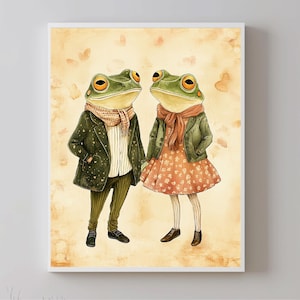 Puede incluir: Una ilustración de acuarela de dos ranas vestidas con ropa. La rana de la izquierda lleva una chaqueta verde con una bufanda marrón y pantalones marrones. La rana de la derecha lleva una chaqueta verde con una bufanda roja y un vestido rosa floral. Ambas ranas se miran.
