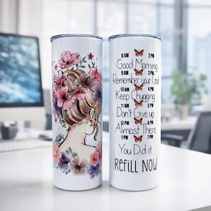 Puede incluir: Dos vasos de acero inoxidable blancos. Uno presenta la silueta de una mujer con cabello floral, el otro tiene texto motivacional y mariposas. El texto incluye "Good Morning", "Remember your Goal" y "Refill NOW".