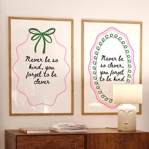 Può includere: Due stampe incorniciate con illustrazioni e testo rosa e verde. Il testo sulla stampa di sinistra recita "Never be so kind, you forget to be clever". Il testo sulla stampa di destra recita "Never be so clever, you forget to be kind".