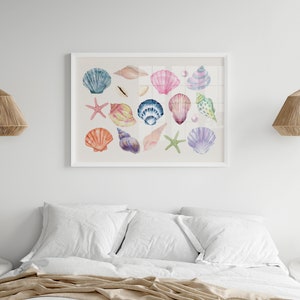 May include: A white framed print with a watercolor illustration of various seashells in shades of pink, blue, purple, and orange. The seashells are arranged in a random pattern on a white background.