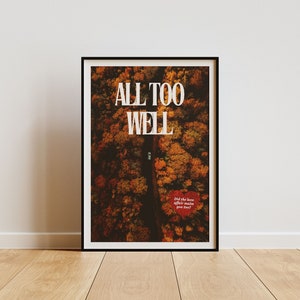 May include: A framed print with a black frame and a white background. The print features an aerial view of a road through a forest with fall foliage. The text "ALL TOO WELL" is printed in white at the top of the print. The text "Did the love affair make you feel?" is printed in red at the bottom of the print.