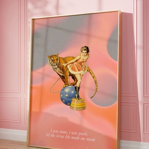 May include: A vintage-style illustration of a woman in a pink dress standing on a circus pedestal with a tiger beside her. The background is a pink and blue gradient with the text "i was tame, i was gentle. til the circus life made me mean".