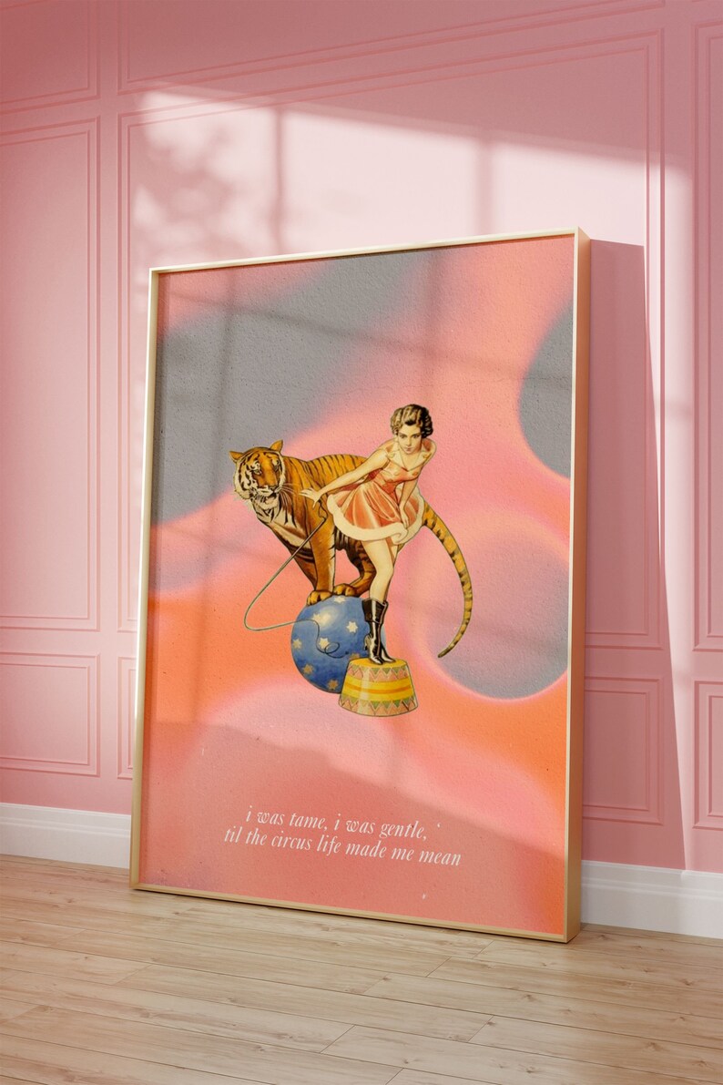 May include: A vintage-style illustration of a woman in a pink dress standing on a circus pedestal with a tiger beside her. The background is a pink and blue gradient with the text "i was tame, i was gentle. til the circus life made me mean".
