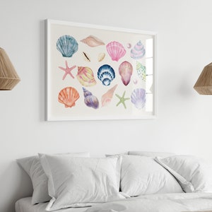May include: A framed watercolor painting of various seashells in shades of pink, blue, purple, and orange. The shells are arranged in a random pattern on a light beige background.