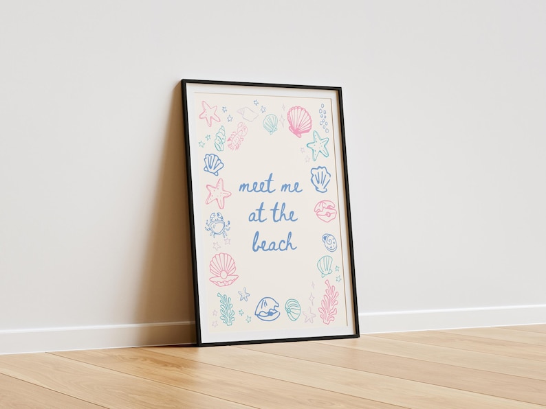 May include: A framed print with a white background and a blue and pink outline of seashells, starfish, and seaweed. The text "Meet me at the beach" is written in blue cursive.