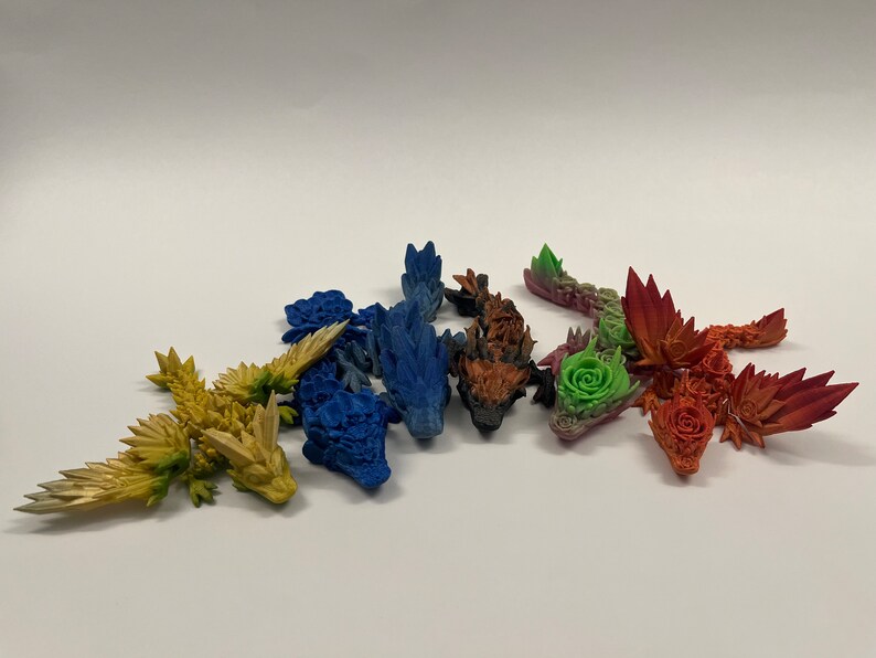 May include: A set of six small, colorful dragon figurines. The dragons are made of a textured material and have a variety of colors, including blue, green, red, orange, yellow, and purple.