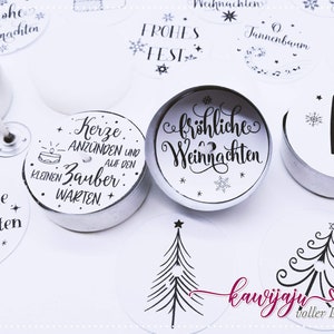 Puede incluir: Surtido de portavelas de té blanco con diseños navideños en blanco y negro. Los diseños incluyen un árbol de Navidad, un muñeco de nieve, una campana y las palabras "Frohes Fest" y "Frohliche Weihnachten".