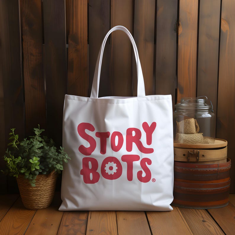 May include: White canvas tote bag with red lettering that says "STORY BOTS" with a small gear symbol in the "O" of "BOTS".