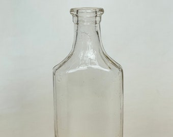 Vintage clear glass pharmacy bottle with capacity graduations