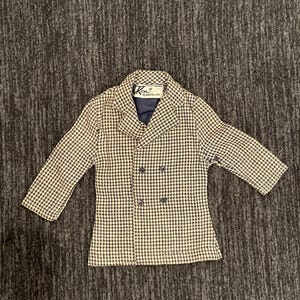May include: A brown and white houndstooth patterned blazer with a double breasted closure and a Ken label.