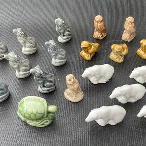 May include: A collection of 17 miniature ceramic figurines, including owls, bears, a turtle, and various animals. The figurines are painted in shades of grey, white, and brown.