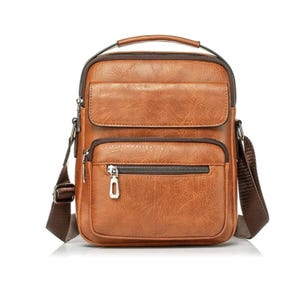May include: A brown leather crossbody bag with a top handle and adjustable shoulder strap. The bag has two zippered compartments and a front flap pocket. The hardware is silver-toned. The bag is designed for everyday use.