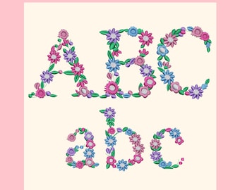 May include: Embroidered floral letters ABC and abc in pink, purple, blue, and green. The letters are on a cream background with a pink border. The flowers are detailed and arranged to form the letters.
