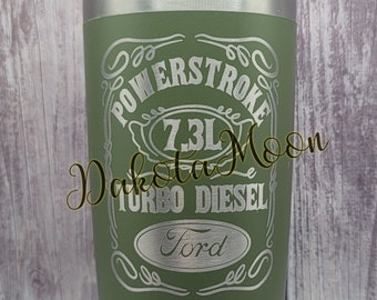 Op de afbeelding: Een groene roestvrijstalen beker met een zilveren deksel. De beker heeft een gegraveerd ontwerp met de tekst "Powerstroke 7.3L Turbo Diesel Ford".