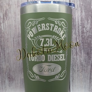 May include: Green stainless steel tumbler with a silver lid. The tumbler has an engraved design that says "Powerstroke 7.3L Turbo Diesel Ford".