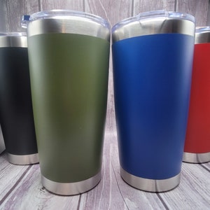 Op de afbeelding: Vier roestvrijstalen bekers met deksels. De bekers zijn in zwart, groen, blauw en rood.