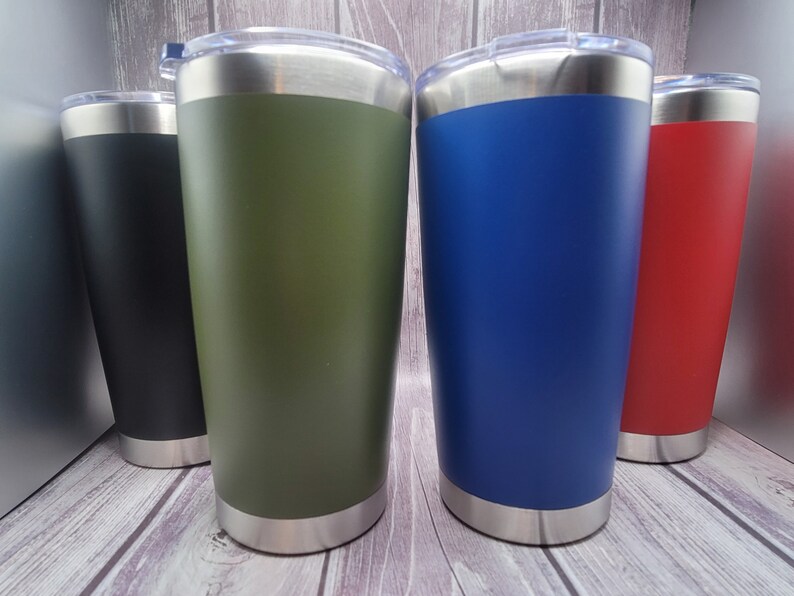 Op de afbeelding: Vier roestvrijstalen bekers met deksels. De bekers zijn in zwart, groen, blauw en rood.