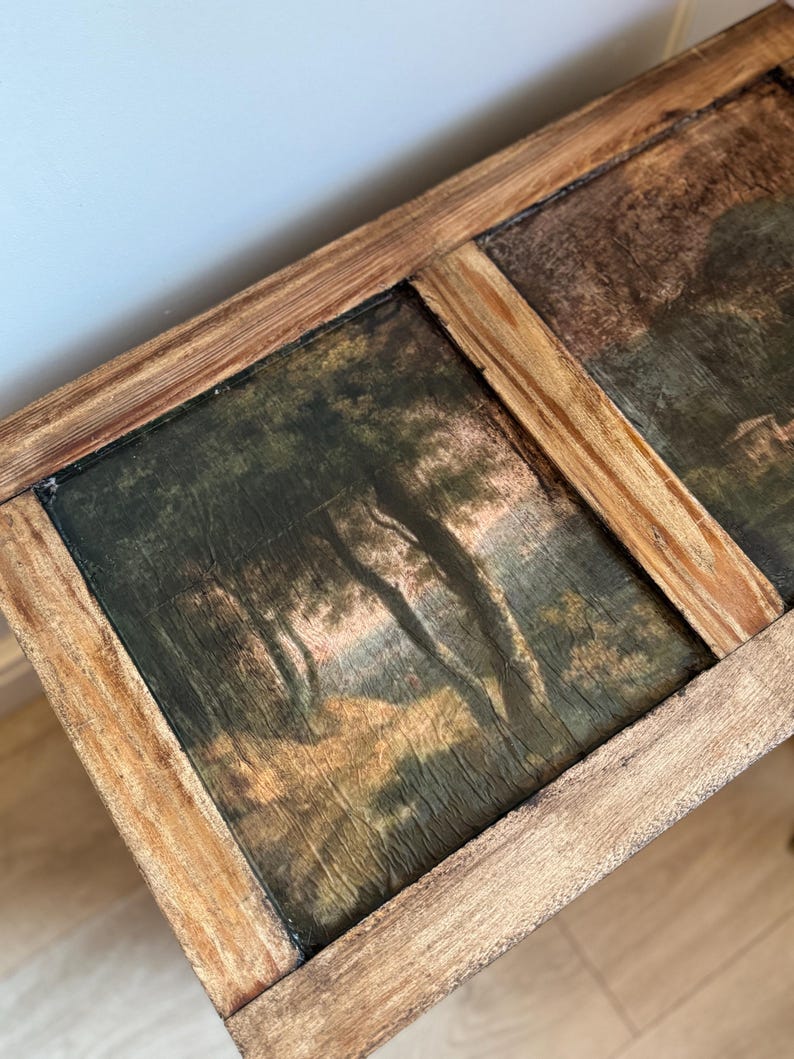 Peut inclure: Une &oelig;uvre d'art rectangulaire encadr&eacute;e de bois, pr&eacute;sentant deux peintures de paysages. Les peintures repr&eacute;sentent des arbres et du feuillage dans des tons verts, bruns et dor&eacute;s. Le cadre en bois a une finition naturelle.