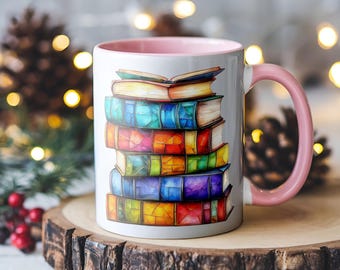 May include: A white ceramic mug with a pink rim and handle. The mug features a colorful illustration of a stack of books with rainbow-colored spines.