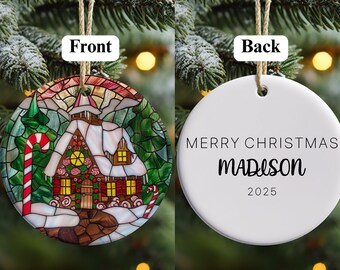 Könnte beinhalten: Runder Weihnachtsschmuck mit einem Buntglasdesign mit einem schneebedeckten Häuschen, einer Zuckerstange und immergrünen Bäumen. Die Rückseite des Schmucks ist weiß mit dem Text "MERRY CHRISTMAS MADISON 2025".