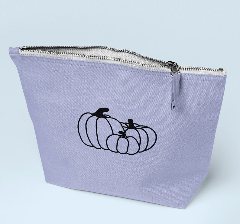 Puede incluir: Una bolsa de cremallera lavanda con un contorno negro de dos calabazas. La calabaza m&aacute;s grande est&aacute; a la izquierda y la m&aacute;s peque&ntilde;a a la derecha.
